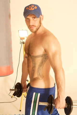 Strong hairy gay athlete Aitor Crash strips naked while lifting weights